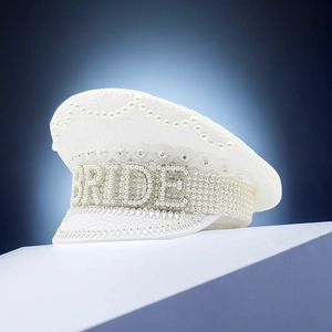 Dettaglio del cappello da capitano bianco con paillettes, perle e la scritta BRIDE