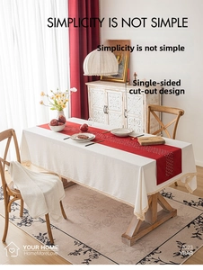 Close-up of beige table runner with geometric laser-cut patterns and wavy lace edges