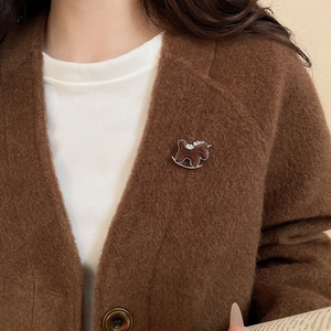 Close-up of a dark brown flocked pony brooch with silver accents on a cardigan