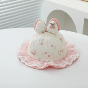 Detail of pink lace brim and cherry print on baby sun hat with large white bow decoration