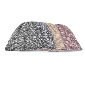 Detail of multi-color knitted beanies showing soft marl texture and inner fabric lining