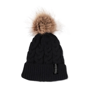 Détail de l'étiquette freedom sur un bonnet en maille torsadée noire avec pompon