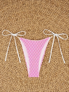 Detail of pink geometric bikini bottom with side ties and pearl metal ring accents