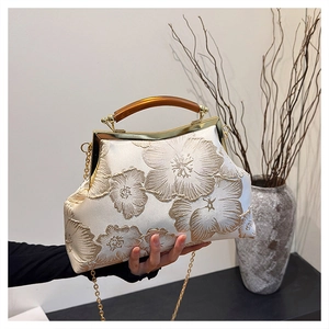 Detail of floral embroidery and amber handle on a vintage satin qipao handbag