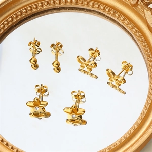 Elegant gold earring set featuring ball, bow, and star studs with crystal details