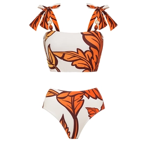 Detail view of tropical leaf print bikini with decorative wooden beads and bow straps