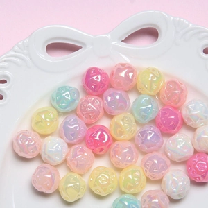 Close-up of colorful DIY flower resin beads scattered on a white ceramic bow plate