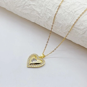 Detail of gold heart pendant necklace featuring shimmering cubic zirconia inlay setting