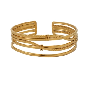 Detail of layered gold cuff bracelet featuring smooth and twisted rope textured metallic bands