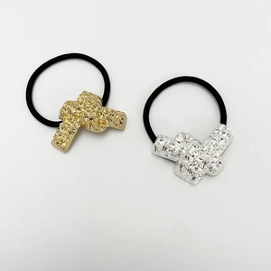 Close-up of gold and silver hammered metal U-shaped hair ties with black elastic bands