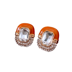 Vintage palace style oval stud earrings with orange enamel and clear crystal accents
