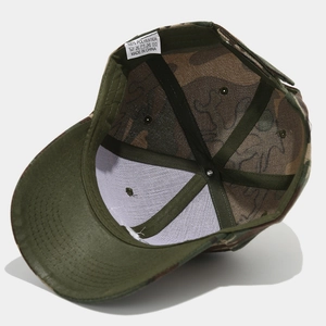Close-up of camouflage baseball cap interior showing black sweatband and polyester care label