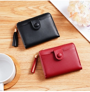 Close-up of black and red PU leather wallets featuring tassel zippers on wooden table