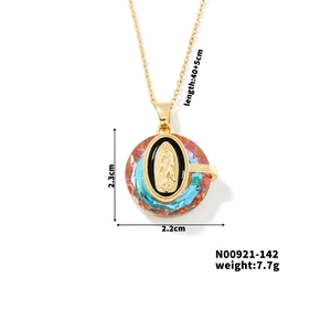 Close-up of golden Virgin Mary pendant with colorful crystals and exact size markers