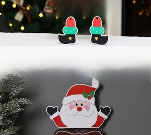 Detail showing Santa Claus holiday door hanger with star boots and wooden holiday sign