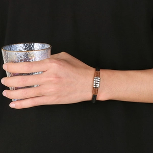 Detail of hand-woven black leather bracelet with stainless steel rings on wrist