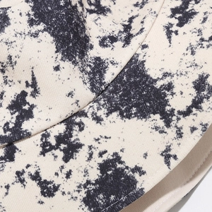 Detailed macro view of the tie-dye pattern and fine stitching on the canvas bucket hat