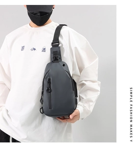 Male model wearing a dark grey matte sling bag with adjustable buckle and front zipper