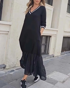 Détail du col en V avec rayures blanches contrastées sur une robe longue noire