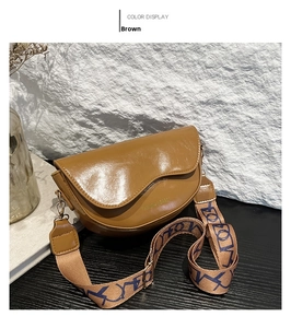 Detail of caramel brown saddle bag featuring a wide jacquard woven shoulder strap
