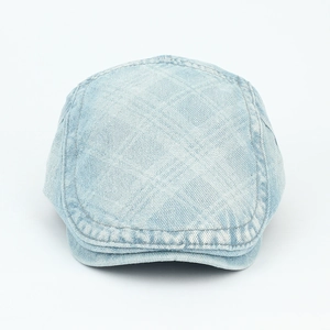 Front view of washed light blue denim newsboy cap showing twill texture and stitching