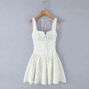 Détail de robe blanche fleurie sans manches avec col carré noué et taille élastique ajustée