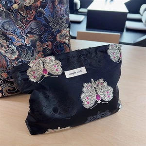 Detail of vintage Chinese brocade makeup bags featuring butterfly and maple leaf embroidery