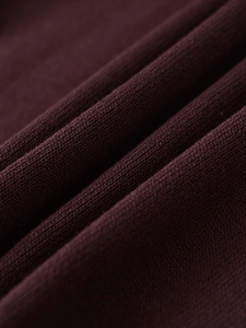 Macro shot of dark burgundy fine knit fabric texture showing soft material detail
