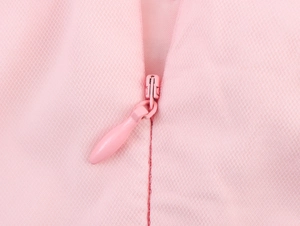 Gros plan d'une robe en tulle rose avec fermeture éclair invisible et coutures soignées