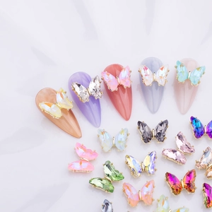 Vista macro de dijes de mariposa de cristal 3D para uñas en varios colores brillantes