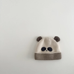 Detailed close-up of a panda-style baby knit hat with embroidered details and soft 3D ears