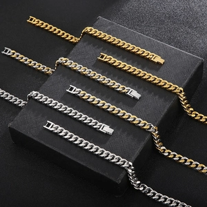 Detail of four colorful Cuban link necklaces on black textured box with metallic luster