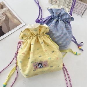 Detail of drawstring pouches with checkered patterns and colorful dot embroidery decor