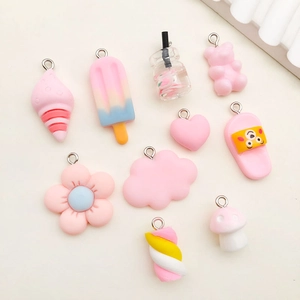Flat lay of 10 pink resin DIY charms with metal rings including bears and hearts