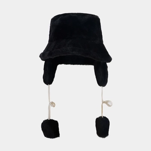Detail of black plush bucket hat with earflaps and soft faux fur texture for winter