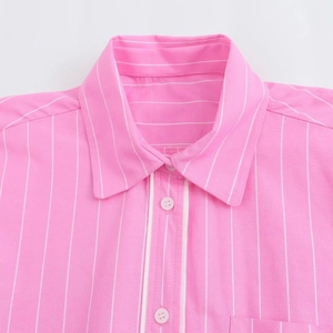 Dettaglio di camicia a righe bianche e rosa con colletto a rever e bottoni