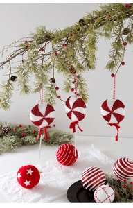Close-up of red and white lollipop-shaped ornaments and glittery Christmas tree balls