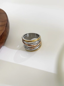 Detailed view of interconnected silver, gold, and rose gold bands with metallic finish