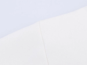 Close-up of high-quality white knitted fabric with detailed stitching and soft texture