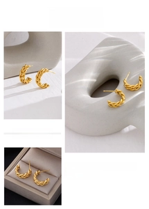 Detailed close-up of gold-plated twisted rope texture on C-shaped stainless steel earrings