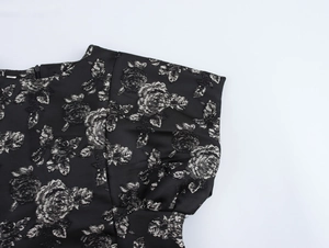 Detail of vintage black floral jacquard fabric with elegant ruffled shoulder design