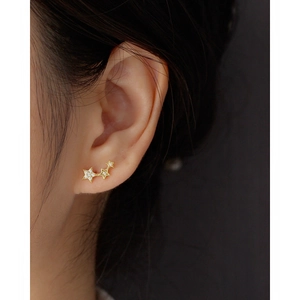 Detailed view of a gold s925 silver earring with three sparkling zircon stars