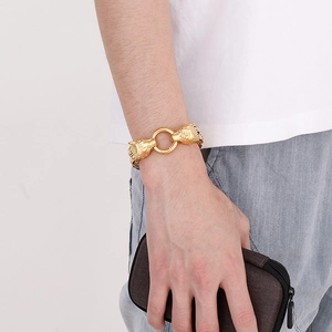 Double wolf head chain bracelet for men in gold titanium steel on a model wrist
