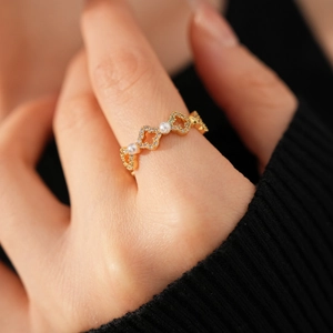 Détail de bague fleur plaquée or 18k avec zircons micro-pavés et perles élégantes