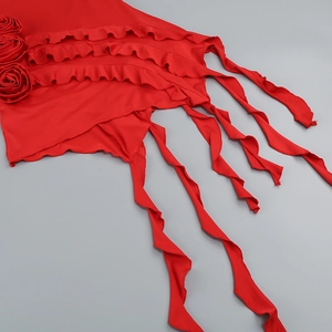 Close-up of red vacation dress featuring handmade 3D flowers and ruffled hem details