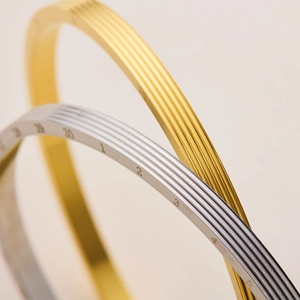 Detailed macro view of gold and silver titanium steel bracelets with scale engravings