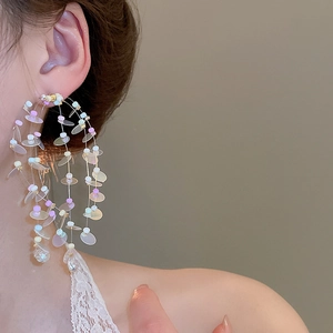 Close-up of oversized colorful layered tassel earrings with iridescent sequins on model