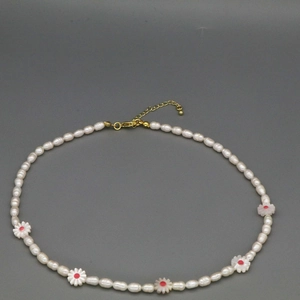 Detail of freshwater pearl necklace with pink daisy charms and gold adjustable clasp