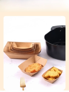 Stackable kraft paper food trays in air fryer with fried chicken on marble background