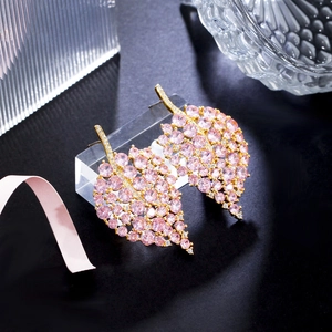 Detailed view of leaf-shaped earrings with pink crystals and gold-plated metal base